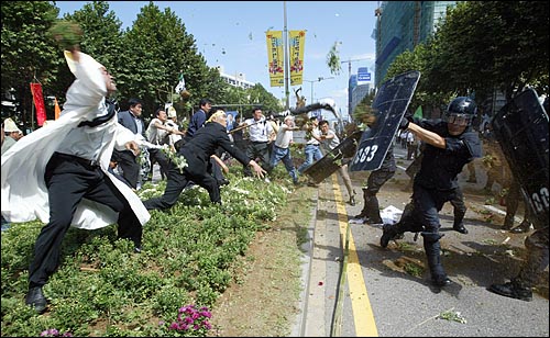 농민들이 경찰을 향해 흙과 화분을 집어 던지고 있다. 